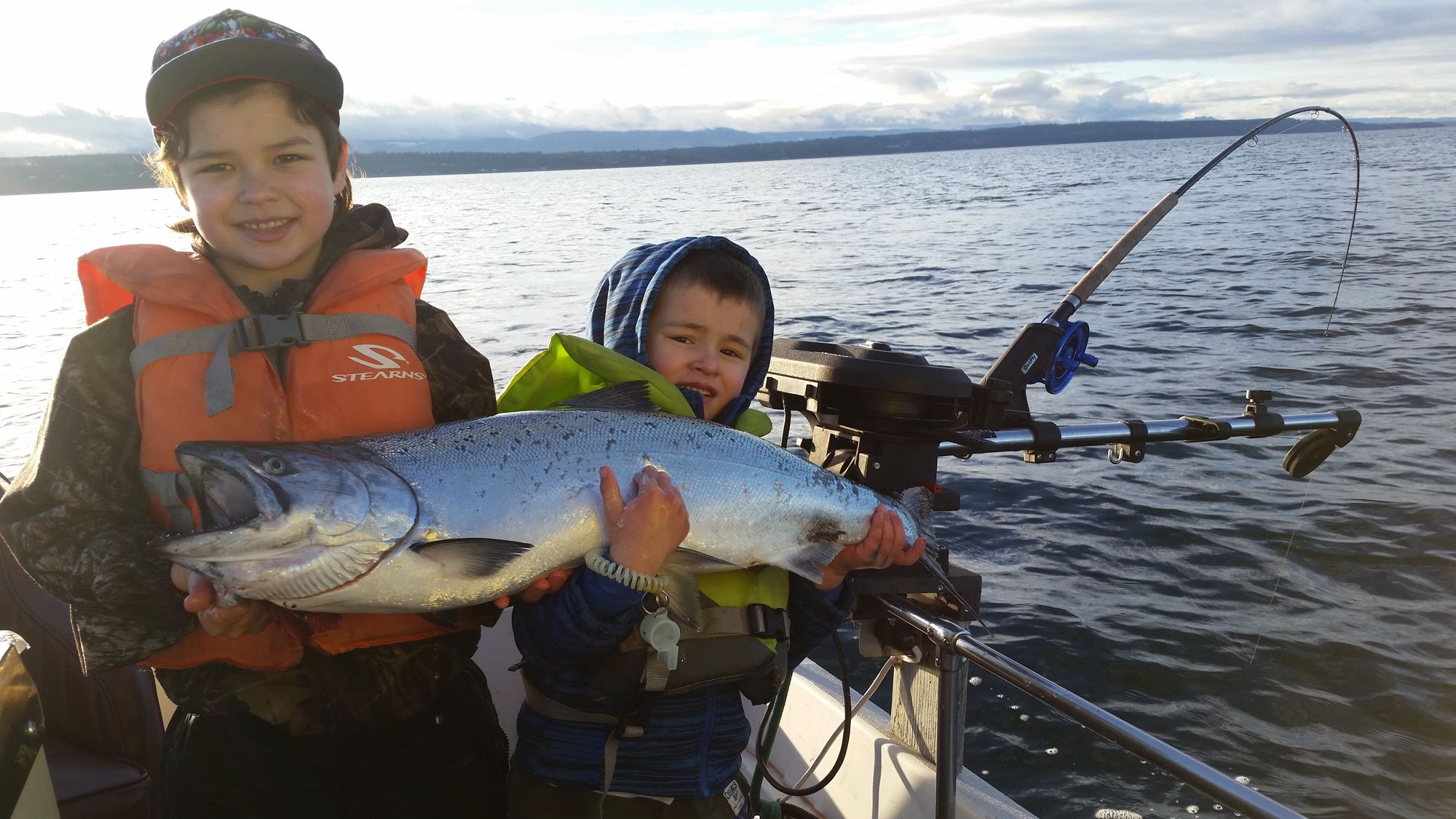 Two young boys hold a single salmon