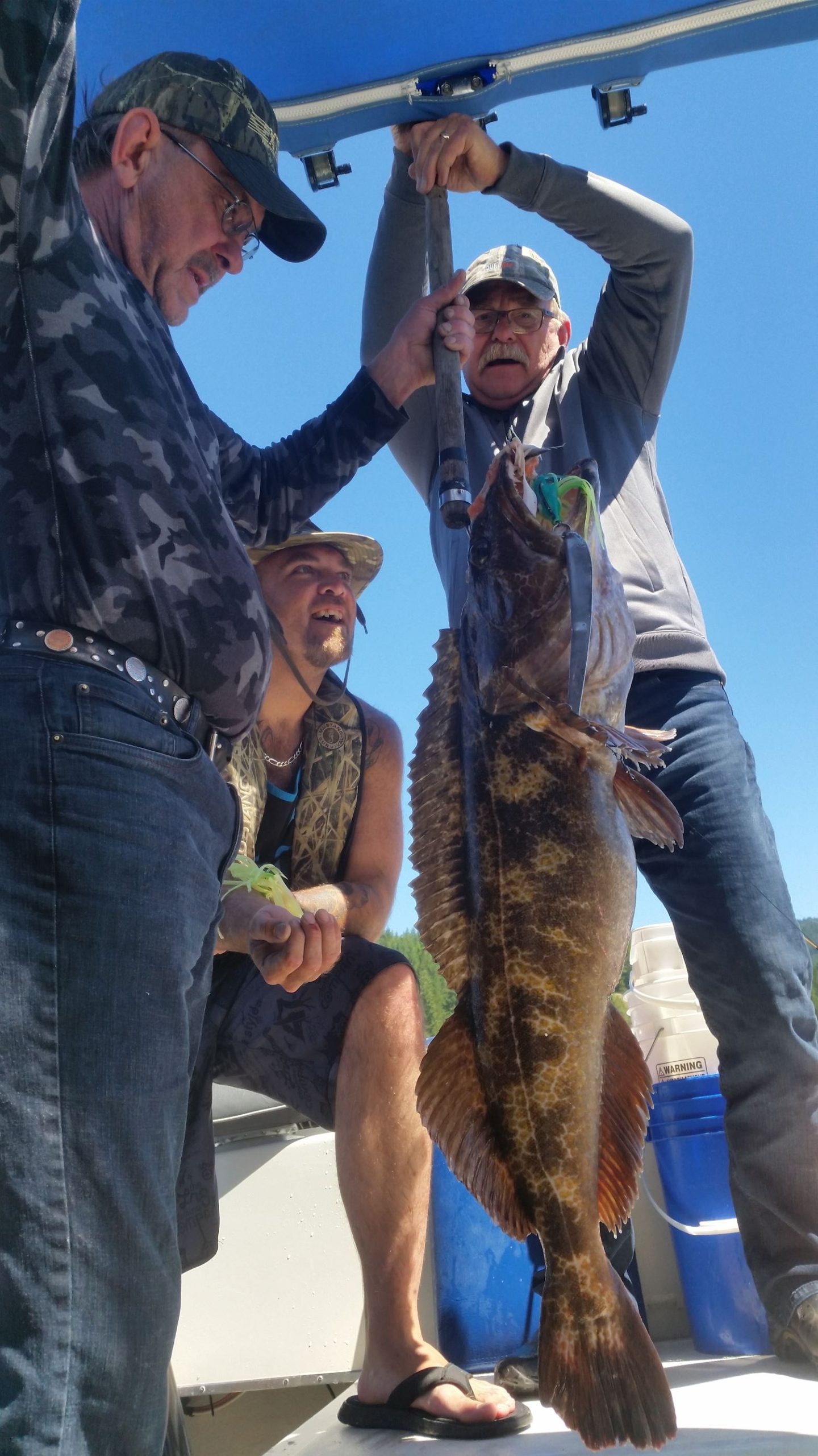 Three men admire the large fish caught on a Slabrador Fishing Charter Trip